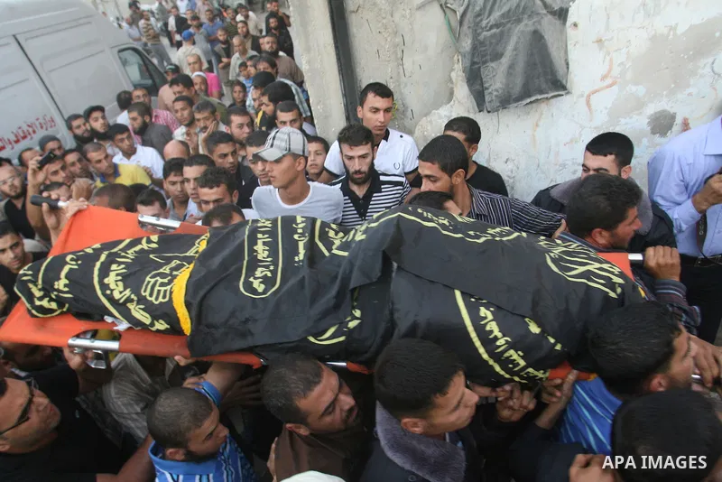 Palestinians carry the body of Abdullah Maqawai during his funeral in Rafah in the southern Gaza Strip on October 8, 2012 after he died of his wounds sustained in an Israeli air strike. Gaza's ruling Hamas movement and t...