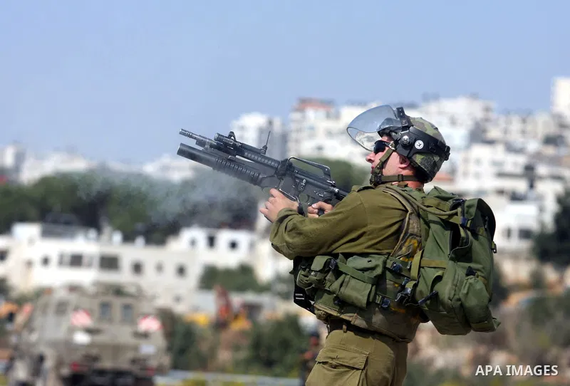 An Israeli border police fires a tear gas during clashes with Palestinian protesters outside Israel's Ofer military prison, near the West Bank city of Ramallah, on October 10, 2012, following a demonstration to demand th...