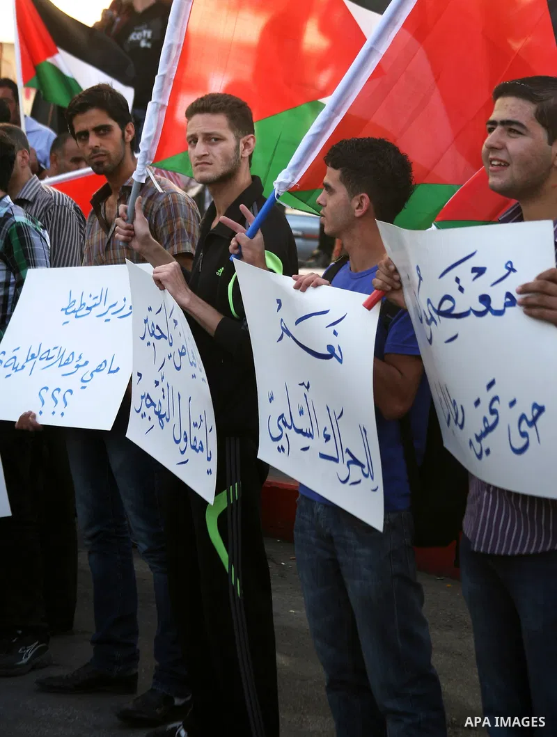 Palestinian protesters hold placards and shout slogans during a demonstration against the financial politics of Prime Minister Salam Fayyad and the high cost of living, in the West Bank city of Hebron, on Oct. 10, 2012....
