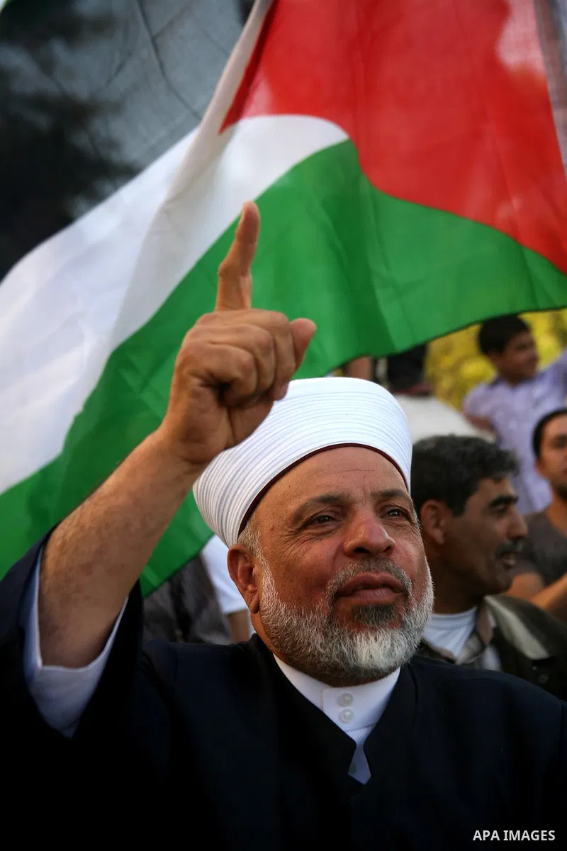 Palestinian protesters hold placards and shout slogans during a demonstration against the financial politics of Prime Minister Salam Fayyad and the high cost of living, in the West Bank city of Hebron, on Oct. 10, 2012....