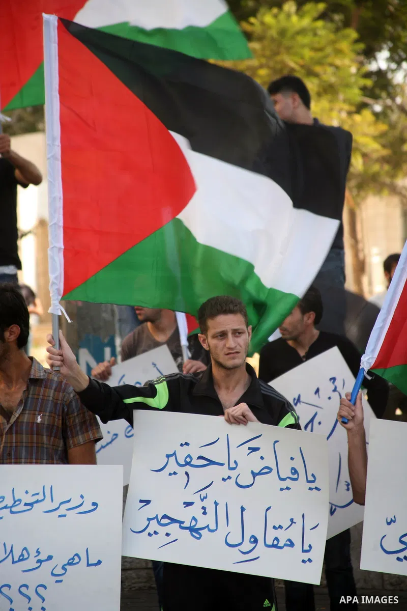 Palestinian protesters hold placards and shout slogans during a demonstration against the financial politics of Prime Minister Salam Fayyad and the high cost of living, in the West Bank city of Hebron, on Oct. 10, 2012....