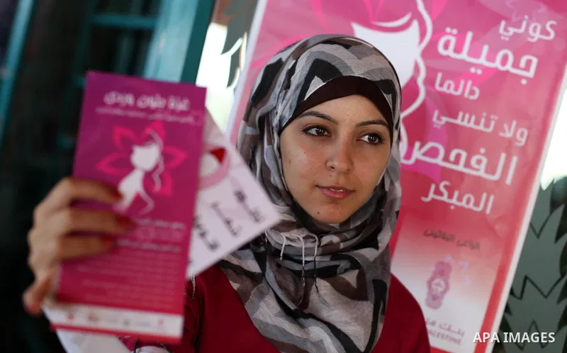 A Palestinian girl display a brochure in Gaza City as part of the Breast Cancer Awareness campaign on October 10, 2012. Photo by Majdi Fathi