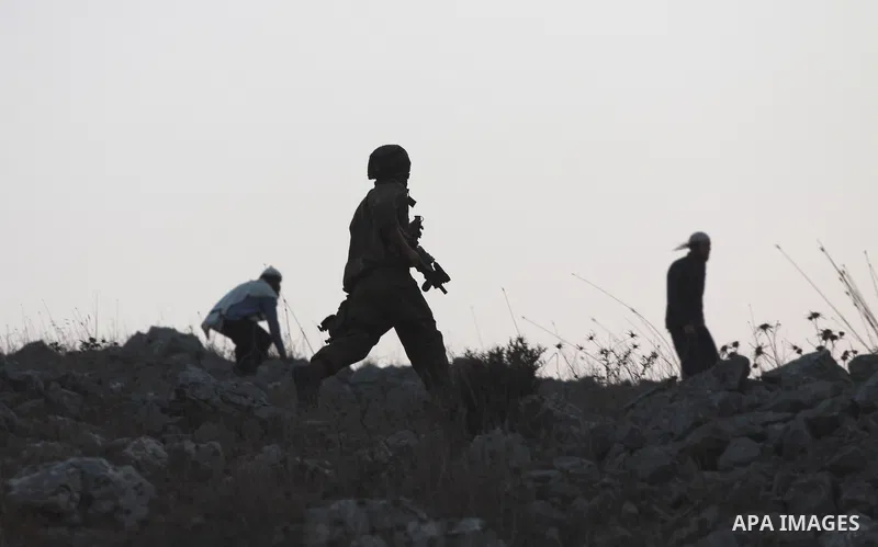 Jewish settlers throw stones toward Palestinian farmers during clashes in the village of Burin near the West Bank city of Nablus on Oct. 10, 2012. Photo by Nedal Eshtayah