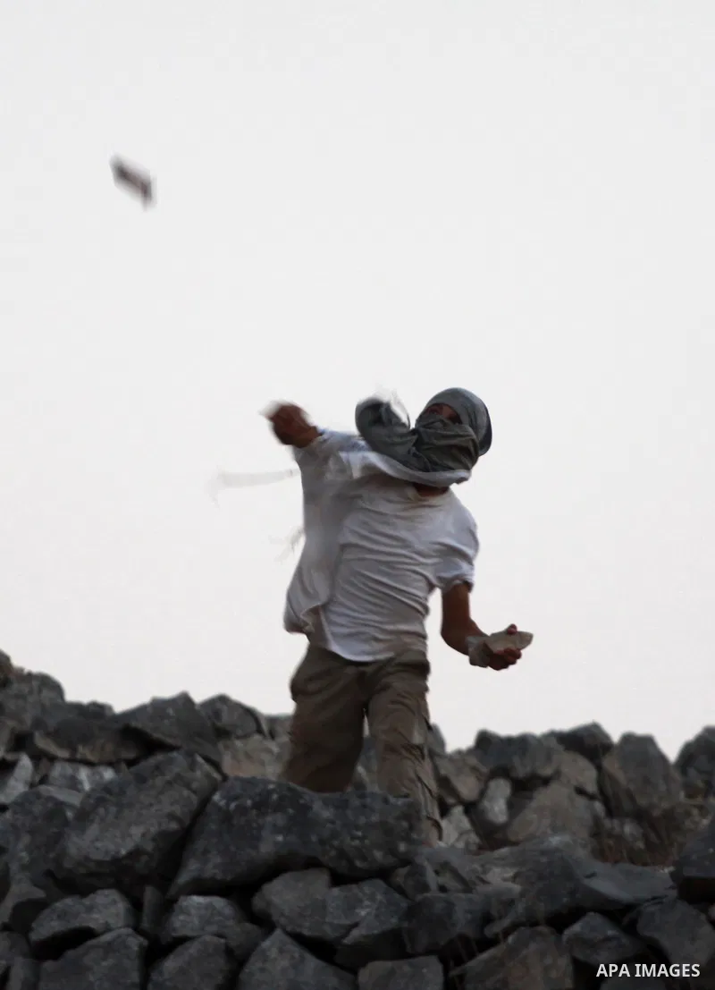Israeli settlers from Bracha settlement throw stones at Palestinian farmers from the West Bank village of Burin, north of Nablus, during clashes on October 10, 2012. Over 100 olive trees belonging to Palestinians in a We...