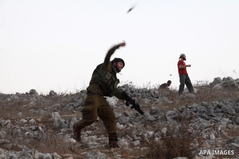 Israeli settlers from Bracha settlement throw stones at Palestinian farmers from the West Bank village of Burin, north of Nablus, during clashes on October 10, 2012. Over 100 olive trees belonging to Palestinians in a We...