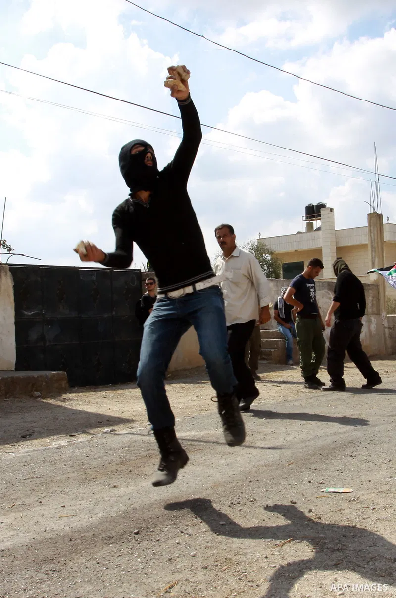Palestinian protesters throw stones towards Israeli soldiers during a demonstration against the expropriation of Palestinian land by Israel in the village of Kfar Qaddum, near the occupied West Bank city of Nablus, on Oc...