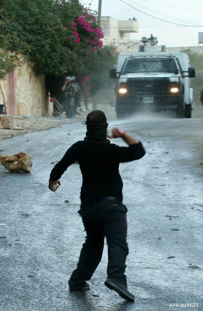 A Palestinian protester throws stones towards Israeli soldiers during a demonstration against the expropriation of Palestinian land by Israel in the village of Kfar Qaddum, near the occupied West Bank city of Nablus, on...