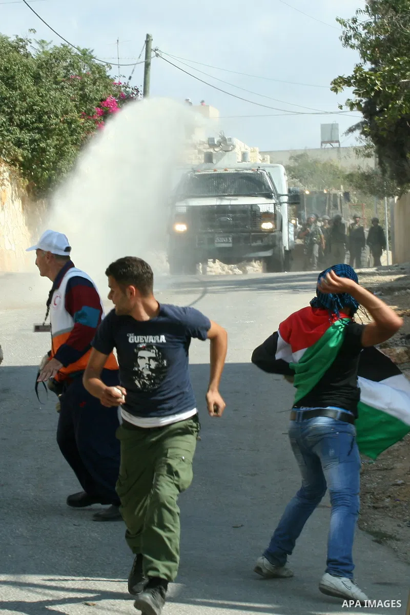 Palestinian protesters throw stones towards Israeli soldiers during a demonstration against the expropriation of Palestinian land by Israel in the village of Kfar Qaddum, near the occupied West Bank city of Nablus, on Oc...