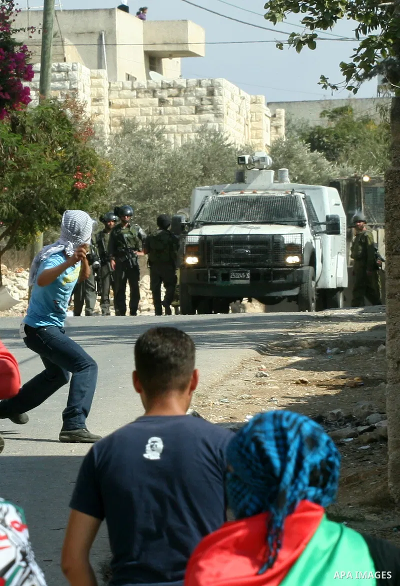 Palestinian protesters throw stones towards Israeli soldiers during a demonstration against the expropriation of Palestinian land by Israel in the village of Kfar Qaddum, near the occupied West Bank city of Nablus, on Oc...