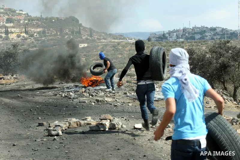 Palestinian protesters throw stones towards Israeli soldiers during a demonstration against the expropriation of Palestinian land by Israel in the village of Kfar Qaddum, near the occupied West Bank city of Nablus, on Oc...