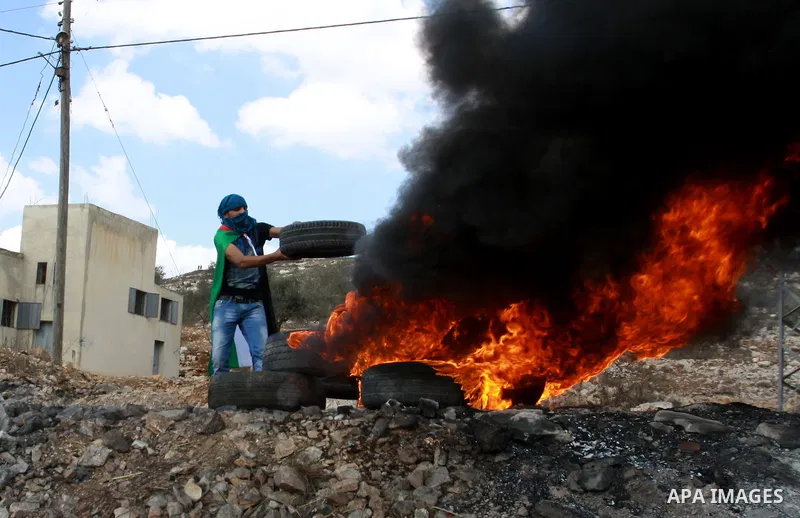 A Palestinian protester throws stones towards Israeli soldiers during a demonstration against the expropriation of Palestinian land by Israel in the village of Kfar Qaddum, near the occupied West Bank city of Nablus, on...