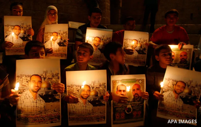 Palestinian children hold pictures of prisoners and candles during a protest calling for the release of Palestinian prisoners from Israeli jails and in support of inmates on hunger strike, outside Damascus Gate in Jerusa...