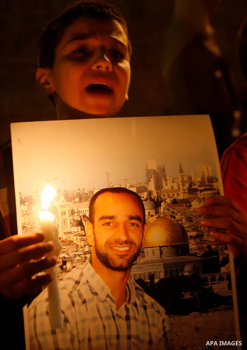 A Palestinian boy holds picture of prisoners and candles during a protest calling for the release of Palestinian prisoners from Israeli jails and in support of inmates on hunger strike, outside Damascus Gate in Jerusalem...