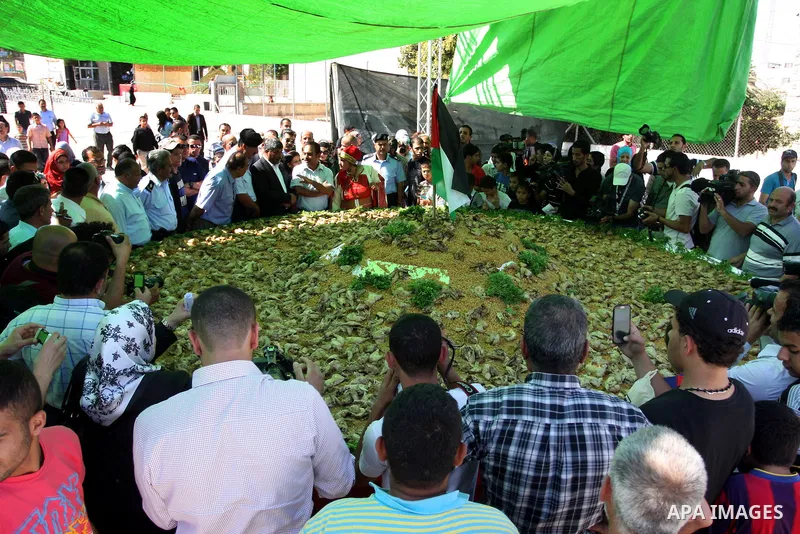 Palestinians participate in the festival largest "Couscous" dish (5 meters), a traditional Palestinian food, in the West Bank city of Ramallah, on Oct. 13, 212. Photo by Issam Rimawi