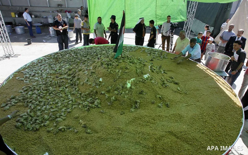 Palestinians participate in the festival largest "Couscous" dish (5 meters), a traditional Palestinian food, in the West Bank city of Ramallah, on Oct. 13, 212. Photo by Issam Rimawi
