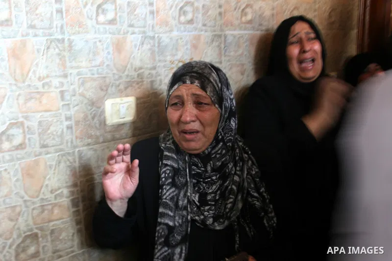 Palestinian relatives mourn over the body of Yasser Al Attal during his funeral in Khan Younis, southern Gaza Strip,on October 14, 2012. An Israeli air strike Saturday on the Gaza Strip has killed the coastal enclave's m...