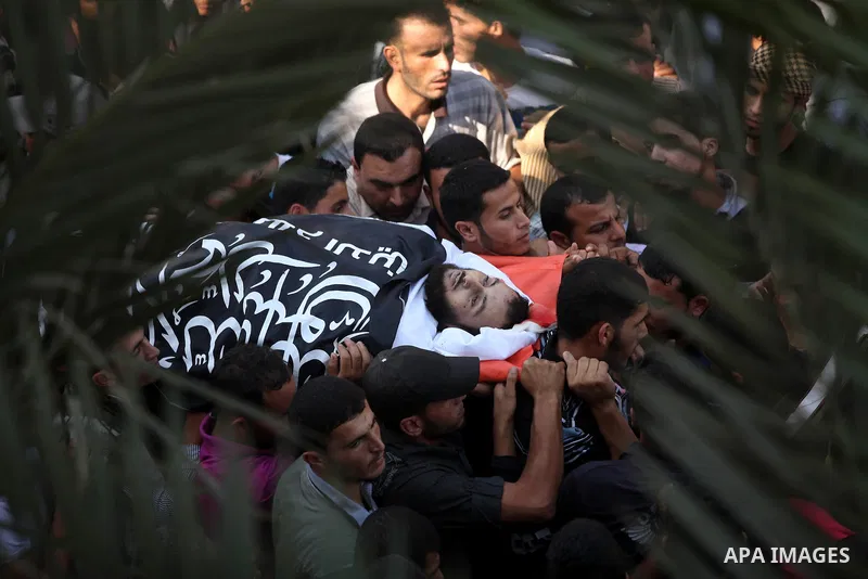 Mourners carry the body of a Palestinian militant, Mohammed Abu Ftair, during his funeral in Deir al-Balah in the central Gaza Strip October 15, 2012. An Israeli air strike in the central Gaza Strip on Sunday killed two...