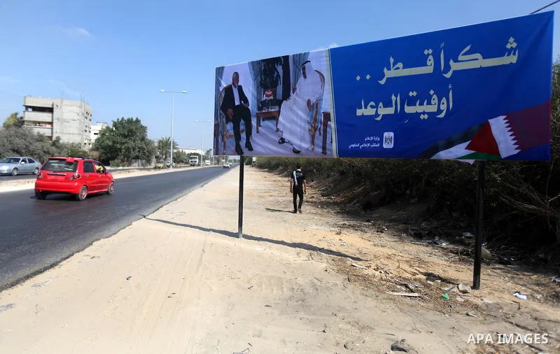 A Palestinian man walks pass a street placard reads in Arabic "Thank Qatar for fit promise" on October 15, 2012. A Qatari delegation headed by Ambassador Mohammed al-Emadi has arrived in Gaza through the Rafah crossing t...