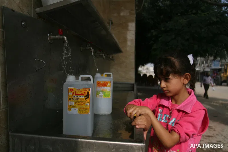 Palestinian children fill plastic bottles with drinking water in Rafah camp southern Gaza Strip, on Oct. 16, 2012. The residents of the Gaza strip suffer from lack of potable water, Israel continues to tighten its blocka...