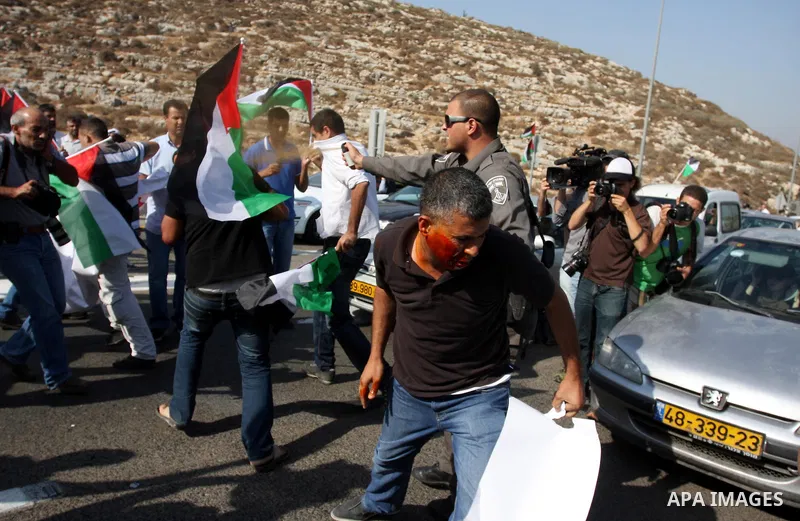 An Israeli border police officer uses pepper spray on activists during a protest on highway 443 near the West Bank village of Beit Ur against what they say are attacks by Jewish settlers on Palestinians and their propert...