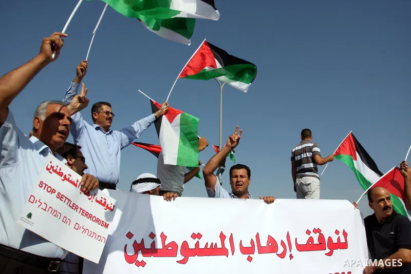 Activists hold Palestinian flags in front of Israeli troops during a protest on highway 443 near the West Bank village of Beit Ur against what they say are attacks by Jewish settlers on Palestinians and their property, O...