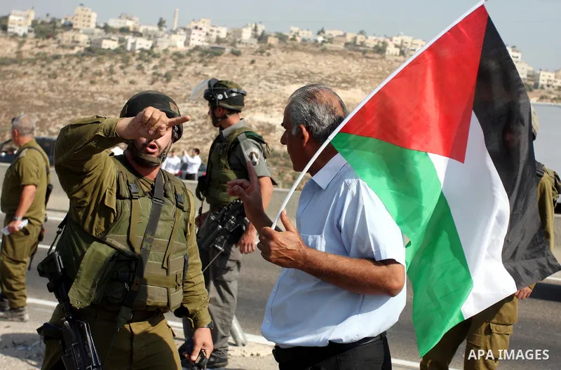 An Israeli border police officer,and an activist argue during a protest on highway 443 near the West Bank village of Beit Ur against what they say are attacks by Jewish settlers on Palestinians and their property, Octobe...