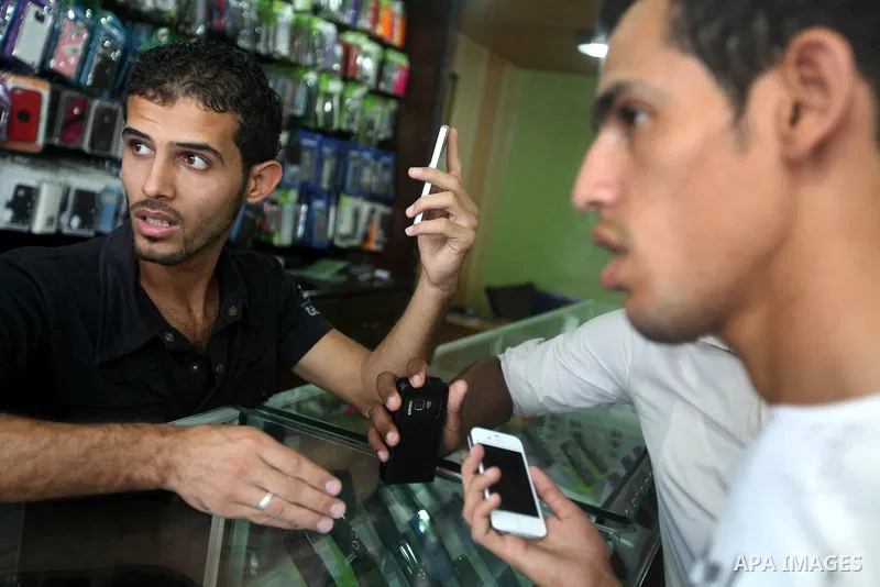 A Palestinian customer holds Apple's new iPhone 5 at a mobile phone store in Gaza City October 16, 2012. Apple's new iPhone 5 is selling well in the Gaza Strip despite inflated prices, reaching the Palestinian enclave vi...