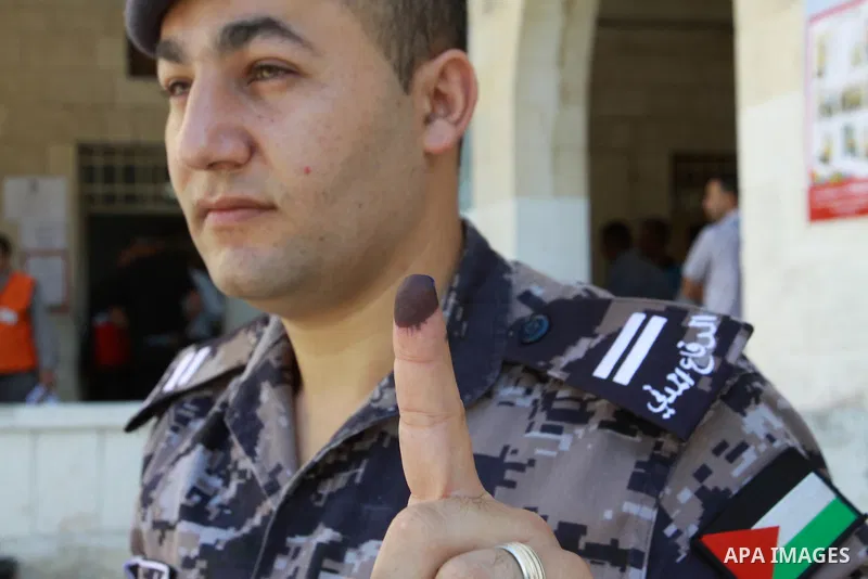 A member of the Palestinian security forces displays his finger after casting his vote during local elections at a polling station in the West Bank city of Jenin, on October 18,2012. Members of Palestinian security force...