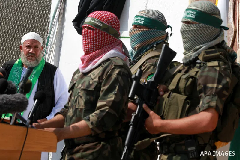 Abu Obaida (C), the spokesman for the Ezzedine Al-Qassam Brigades, the armed wing of Hamas, speaks during a news conference on October 18, 2012 at the Rafah border crossing with Egypt in the southern Gaza Strip to mark t...
