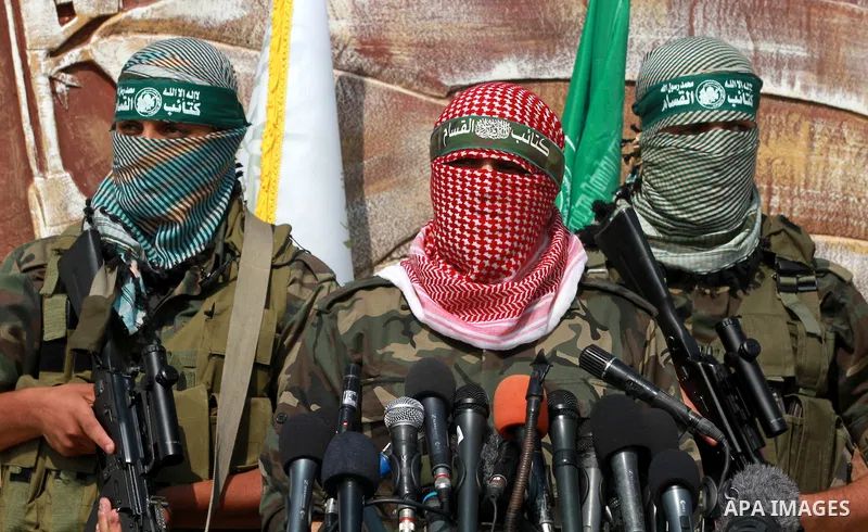 Abu Obaida (C), the spokesman for the Ezzedine Al-Qassam Brigades, the armed wing of Hamas, speaks during a news conference on October 18, 2012 at the Rafah border crossing with Egypt in the southern Gaza Strip to mark t...