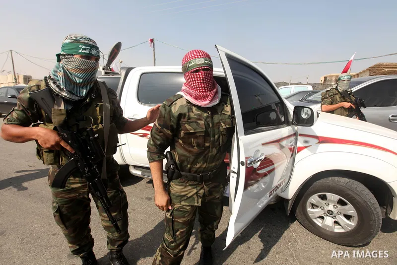 Abu Obaida (C), the spokesman for the Ezzedine Al-Qassam Brigades, the armed wing of Hamas, speaks during a news conference on October 18, 2012 at the Rafah border crossing with Egypt in the southern Gaza Strip to mark t...