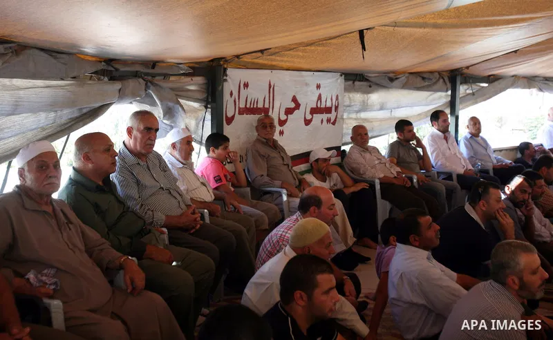 Palestinian Muslim worshippers attend Friday prayers outside a protest tent against the continuing 'Judaization of Jerusalem' by Jewish settlers, in the mostly Arab neighbourhood of Silwan in east Jerusalem on Oct. 19, 2...