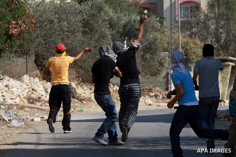 Palestinian protesters throw stones on towards Israeli soldiers during clashes following a demonstration against the expropriation of Palestinian land by Israel in the village of Kfar Qaddum, near the occupied West Bank...
