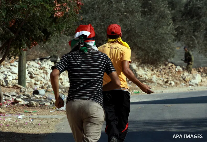 Palestinian protesters throw stones on towards Israeli soldiers during clashes following a demonstration against the expropriation of Palestinian land by Israel in the village of Kfar Qaddum, near the occupied West Bank...