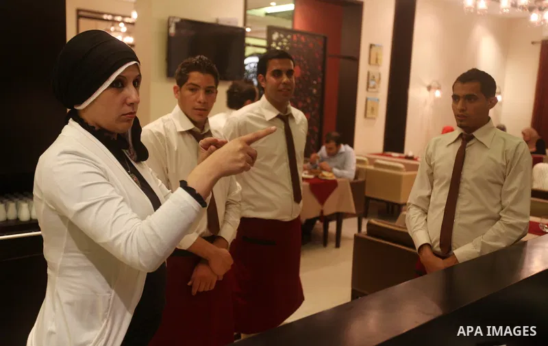 A hearing-impaired employee uses sign language to communicate with his co-worker on October 18, 2012 at the first restaurant that employs deaf people in Gaza, which officially opened earlier this week in Gaza city. The r...
