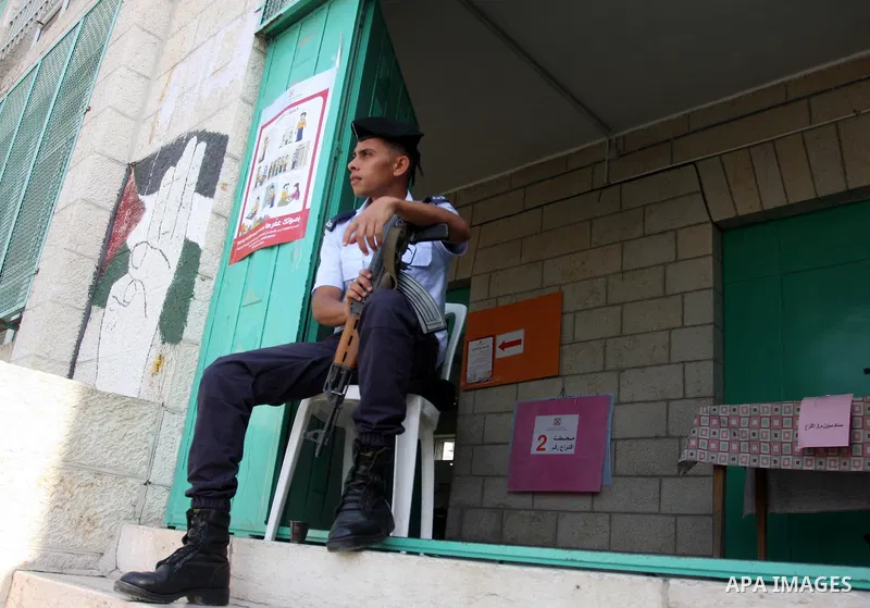 A Palestinian policeman sits guard at a polling station in Al-Bireh, a town adjacent to the West Bank city of Ramallah, on October 20, 2012. Palestinians in the West Bank voted in local elections in what was the first ti...