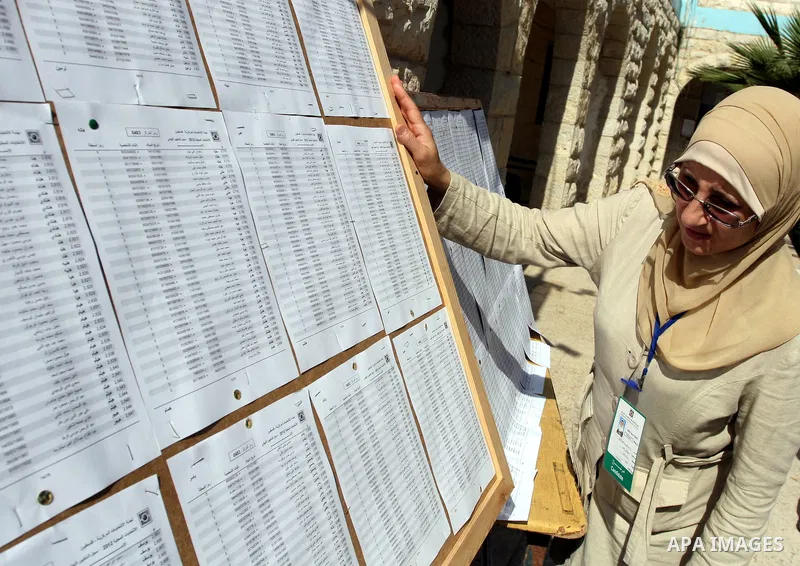 A Palestinian woman looks for his name on the registered voters' list outside a polling station in the West Bank city of Ramallah on October 20, 2012. Ballot booths opened across the West Bank as Palestinians began votin...