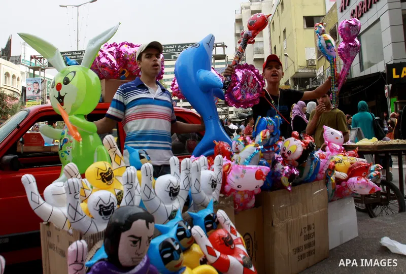 A Palestinian vendor sells ballons in preparing to the celebration of Eid al-Adha festival at a market in the West Bank city of Nablus, oct. 21, 2012. Muslims around the world prepare to celebrate Eid Al-Adha, which acco...