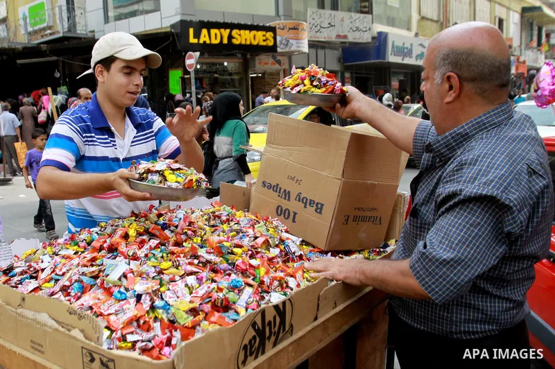 A Palestinian vendor sells candy in preparing to the celebration of Eid al-Adha festival at a market in the West Bank city of Nablus, oct. 21, 2012. Muslims around the world prepare to celebrate Eid Al-Adha, which accord...