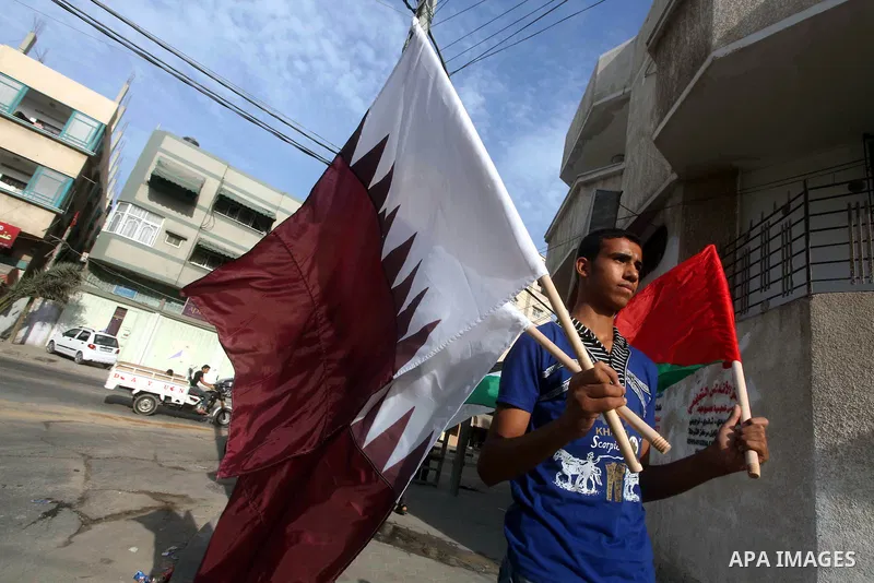 Palestinians carry the Qatari and Palestinian (red,black,white, green) flags in Gaza City on October 21, 2012, the day before the Emir of Qatar's official visit to the strip. Emir of Qatar Hamad bin Khalifa Al Thani visi...