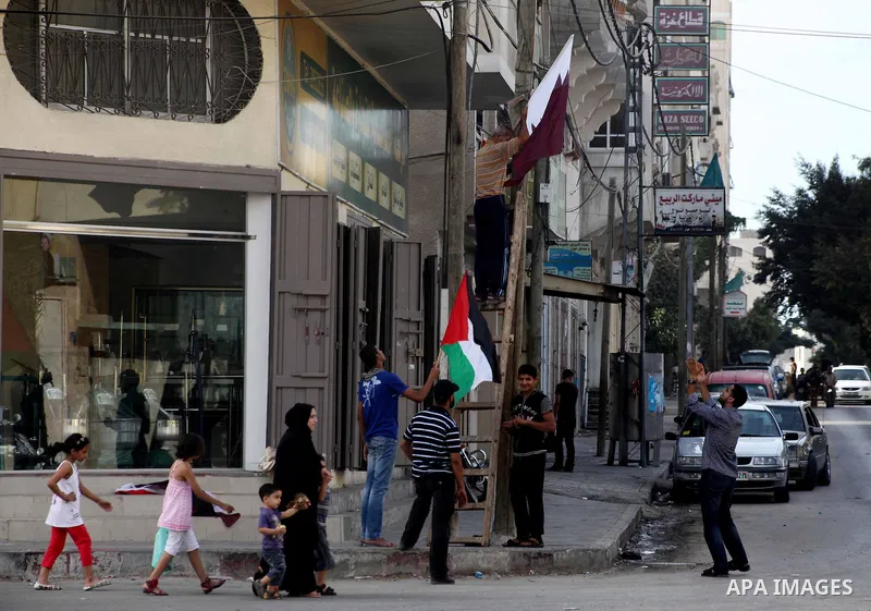 The Qatari and Palestinian (red,black,white, green) flags are attached to lamp posts along a main street in Gaza City on October 21, 2012, the day before the Emir of Qatar's official visit to the strip. Emir of Qatar Ham...