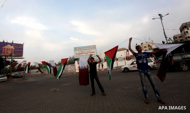 Palestinians carry the Qatari and Palestinian (red,black,white, green) flags in Gaza City on October 21, 2012, the day before the Emir of Qatar's official visit to the strip. Emir of Qatar Hamad bin Khalifa Al Thani visi...