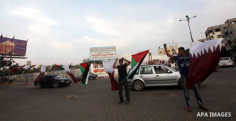 Palestinians carry the Qatari and Palestinian (red,black,white, green) flags in Gaza City on October 21, 2012, the day before the Emir of Qatar's official visit to the strip. Emir of Qatar Hamad bin Khalifa Al Thani visi...