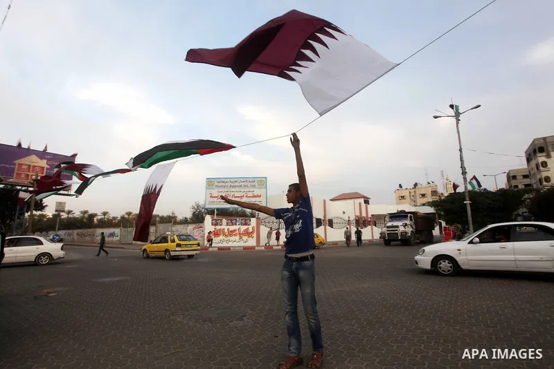 Palestinians carry the Qatari and Palestinian (red,black,white, green) flags in Gaza City on October 21, 2012, the day before the Emir of Qatar's official visit to the strip. Emir of Qatar Hamad bin Khalifa Al Thani visi...