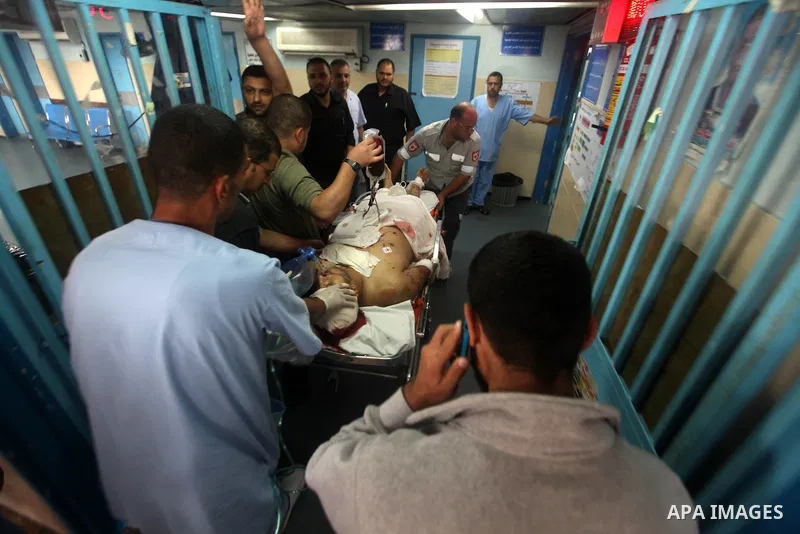 Health workers wheel a wounded Palestinian man from the village of Beit Lahia in the northern Gaza Strip outside the al-Shafa hospital in Gaza City on October 22, 2012, following as Israeli airstrike. Three Palestinians...