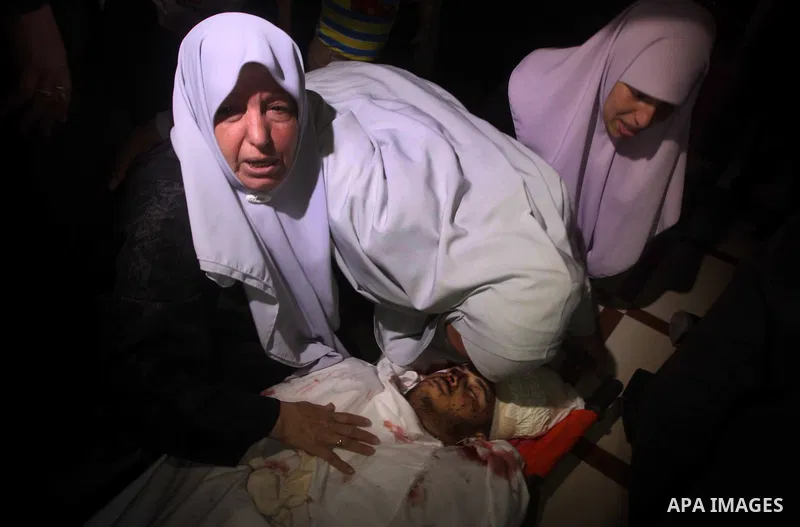 Palestinian women mourn over the body of Abderahman Abu Jalaleh, 25, during his funeral in Beit Lahia, in the northern Gaza Strip, on October 22, 2012. An Israeli air strikes killed two Gaza militants as they clashed wit...