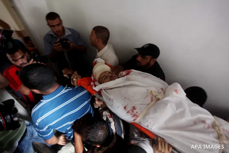 Palestinian women mourn over the body of Abderahman Abu Jalaleh, 25, during his funeral in Beit Lahia, in the northern Gaza Strip, on October 22, 2012. An Israeli air strikes killed two Gaza militants as they clashed wit...