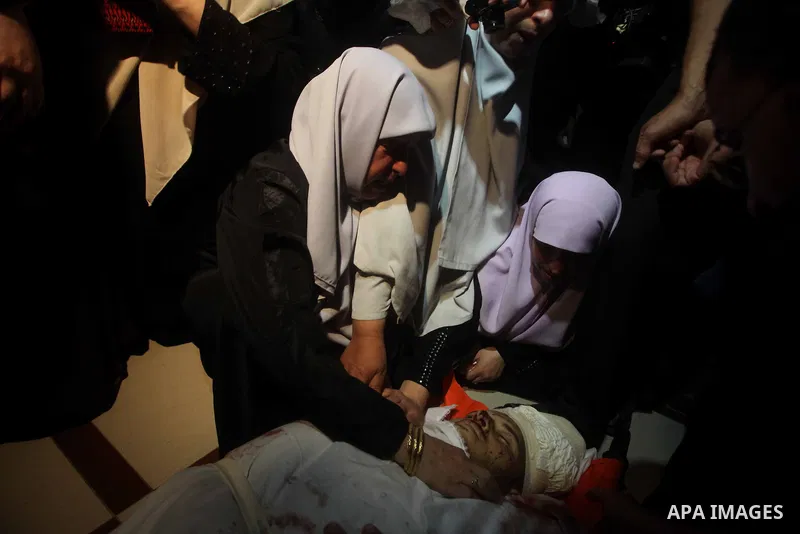 Palestinian women mourn over the body of Abderahman Abu Jalaleh, 25, during his funeral in Beit Lahia, in the northern Gaza Strip, on October 22, 2012. An Israeli air strikes killed two Gaza militants as they clashed wit...