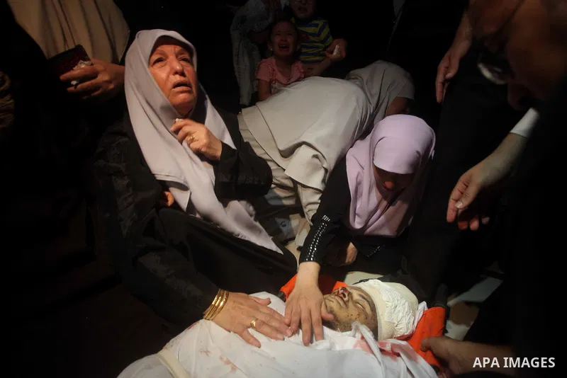 Palestinian women mourn over the body of Abderahman Abu Jalaleh, 25, during his funeral in Beit Lahia, in the northern Gaza Strip, on October 22, 2012. An Israeli air strikes killed two Gaza militants as they clashed wit...