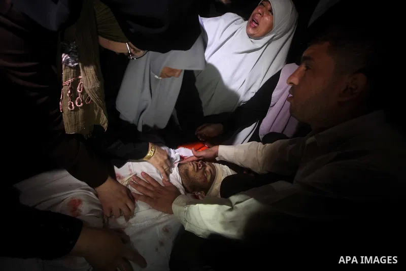 Palestinian women mourn over the body of Abderahman Abu Jalaleh, 25, during his funeral in Beit Lahia, in the northern Gaza Strip, on October 22, 2012. An Israeli air strikes killed two Gaza militants as they clashed wit...